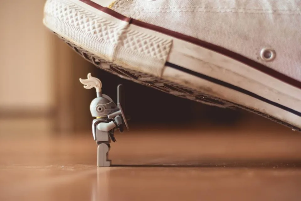 Small toy robot figure next to a sneaker
